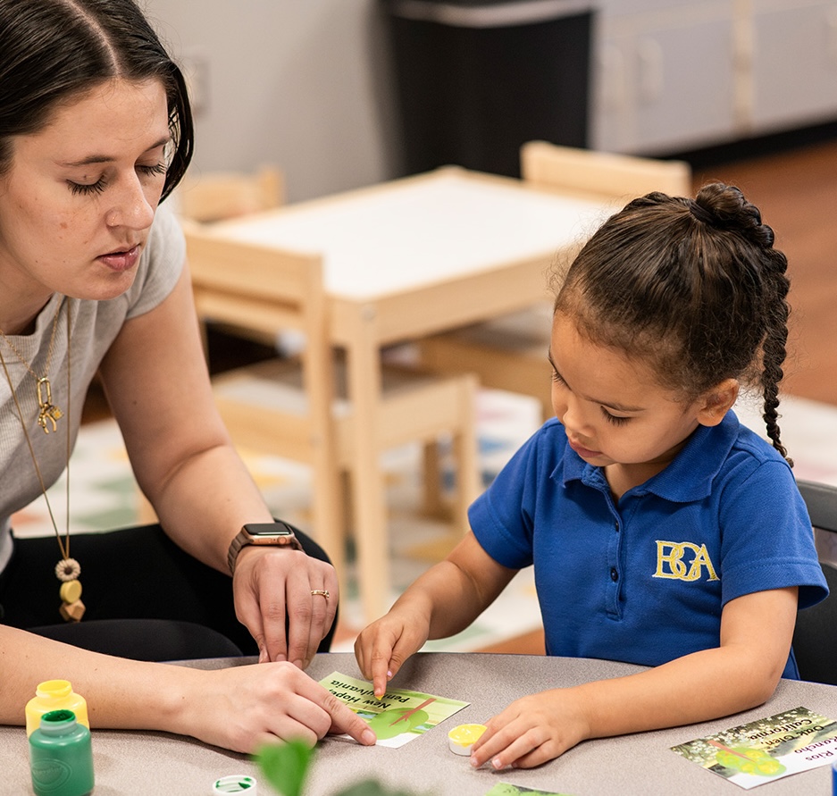 photo of student at table with teacher